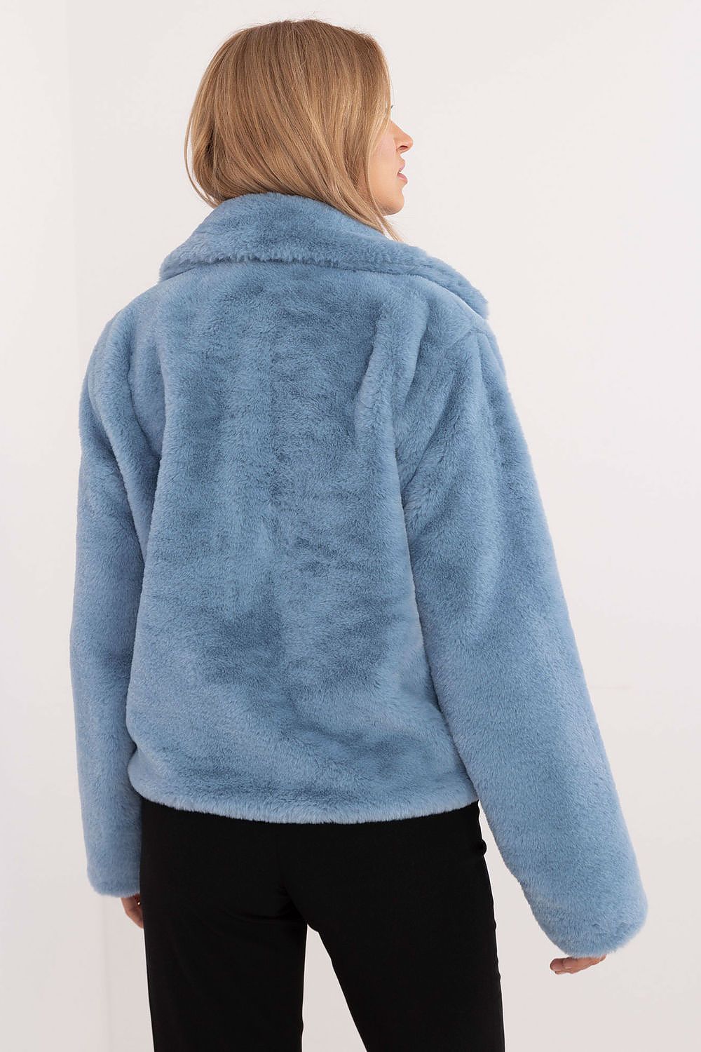 Back view of a woman wearing a blue fur-collar viscose jacket with long sleeves and a smooth finish, paired with black pants.