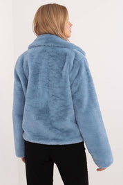 Back view of a woman wearing a blue fur-collar viscose jacket with long sleeves and a smooth finish, paired with black pants.