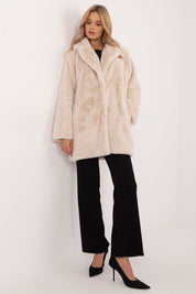 Woman wearing a sophisticated knee-length beige coat, styled for autumn-winter transition, combining comfort and elegance.