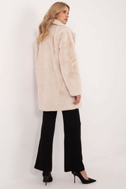 Woman wearing a beige viscose mid-season coat with knee-length coverage and black trousers, showcasing autumn-winter fashion.