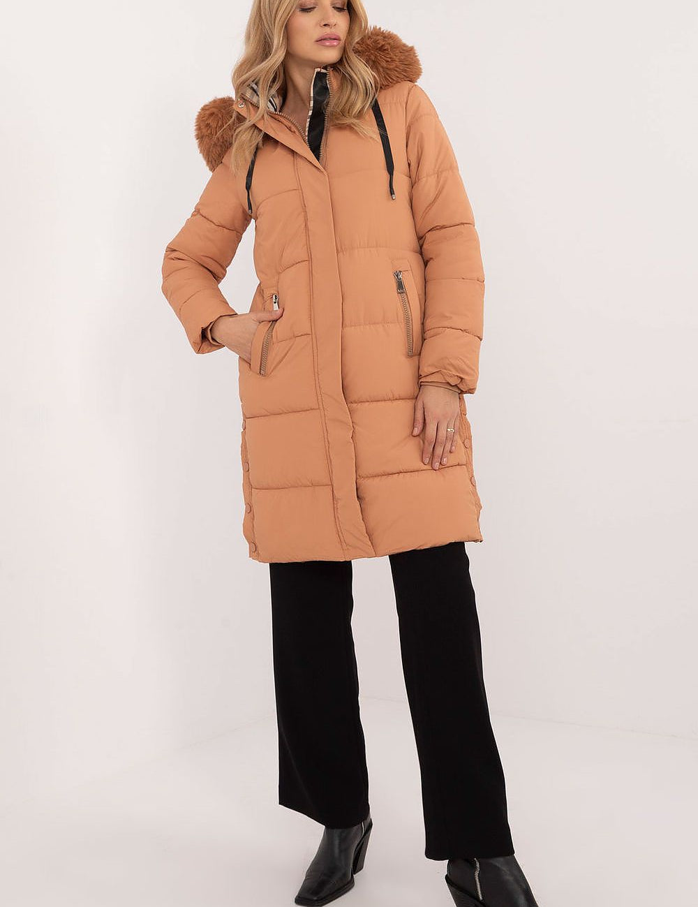 Woman wearing Arden Quilted Longline Winter Jacket with detachable hood and fur trim, showcasing warmth and elegance.