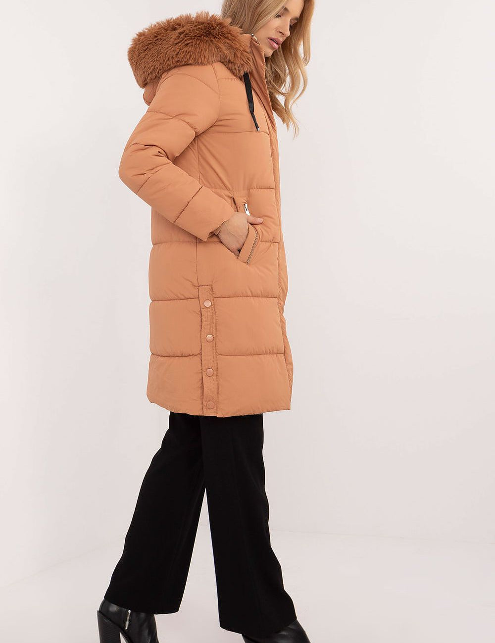 Side view of a woman wearing an Arden Quilted Longline Winter Jacket with detachable hood and fur trim, showcasing warmth and elegance.