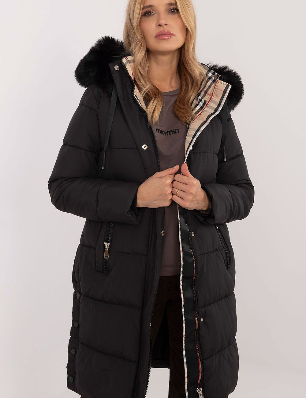Woman wearing Arden Quilted Longline Winter Jacket with detachable hood and fur trim, showcasing warmth and style for cold seasons.