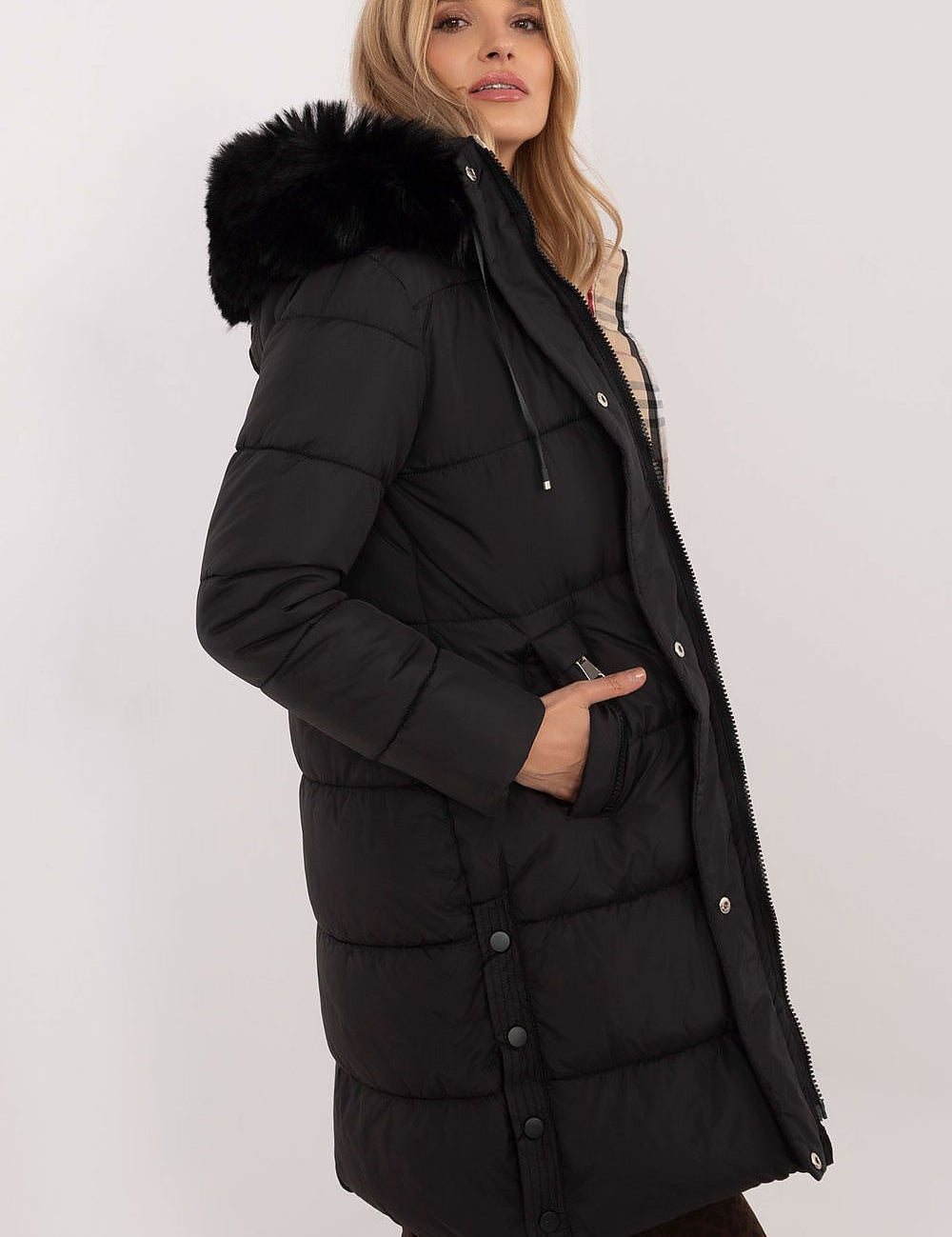Woman wearing Arden Quilted Longline Winter Jacket with detachable hood and fur trim, knee-length, perfect for autumn and winter.