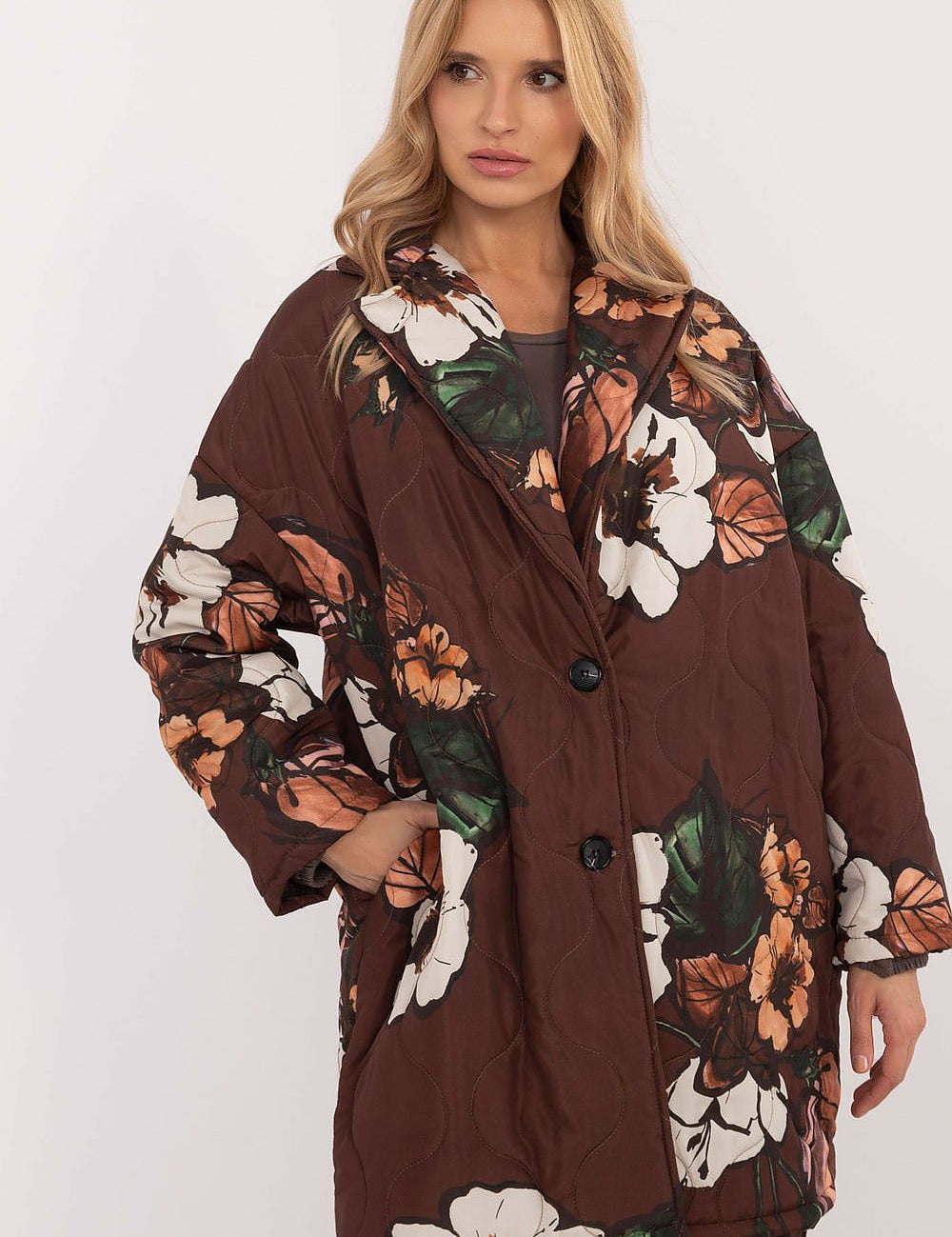 Woman wearing Florencia floral-print longline jacket with structured lapels and button closure, ideal for cooler weather.