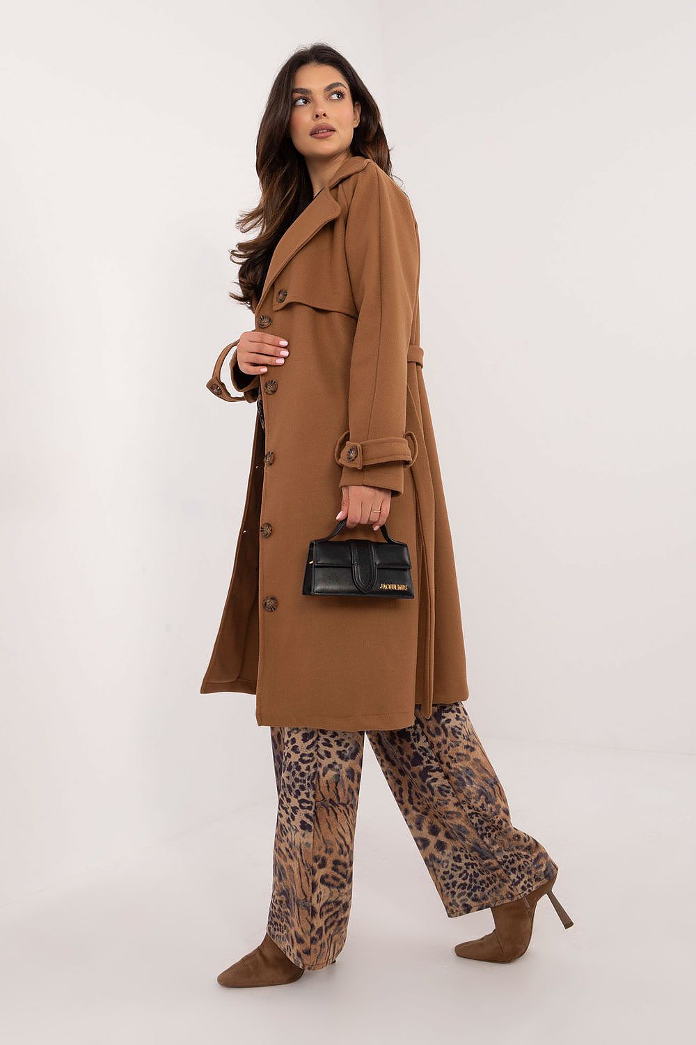 Woman wearing Meriselle Belted Weather-Resistant Trench coat, holding black handbag, styled with leopard print pants and brown heels.