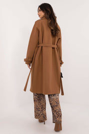 Back view of a woman wearing a Meriselle Belted Weather-Resistant Trench coat, showing the sleek design and waist belt over patterned pants.