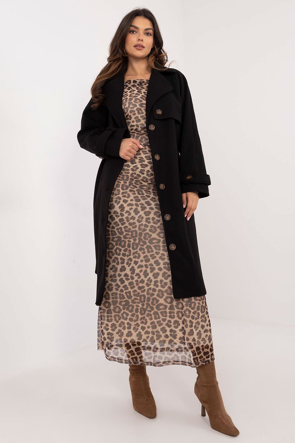 Woman in leopard print dress wearing a black trench coat with button closure, showcasing a stylish and weather-resistant fashion choice.