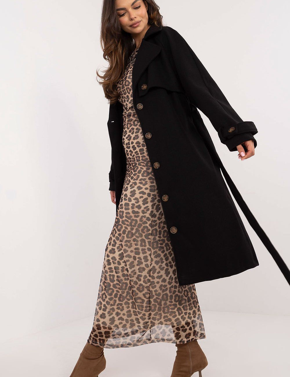 Woman modeling black Meriselle Belted Weather-Resistant Trench Coat over animal print dress with long sleeves and button closure.