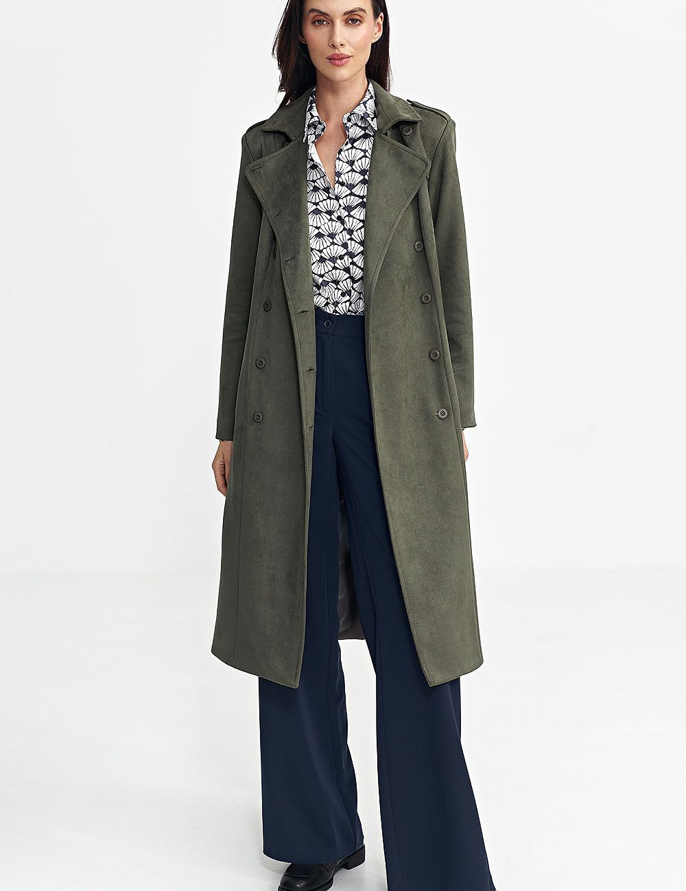 Woman wearing Aurivanne Nubuck Trench Coat with decorative shoulder epaulettes and button details, paired with wide-leg pants and printed shirt.