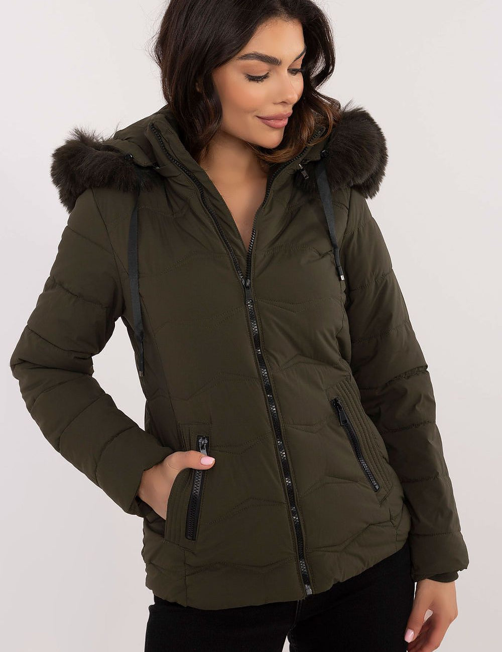 Woman wearing Veyra Short Quilted Jacket with detachable hood and front zipper, showcasing a stylish and warm design.