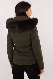 Back view of woman wearing Veyra Short Quilted Jacket in green with detachable hood and faux fur trim, showcasing quilted design.