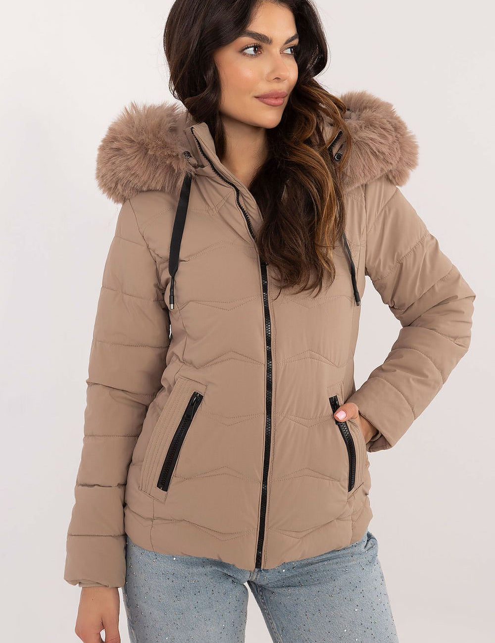 Woman wearing Veyra short quilted jacket with detachable hood and sleek silhouette for cold-weather style.