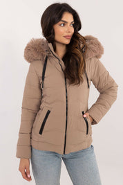 Woman wearing Veyra short quilted jacket with detachable hood and sleek silhouette for cold-weather style.