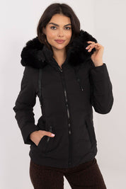 Woman wearing Veyra Short Quilted Jacket with detachable hood and full front zipper, featuring a sleek design and synthetic down filling for warmth.
