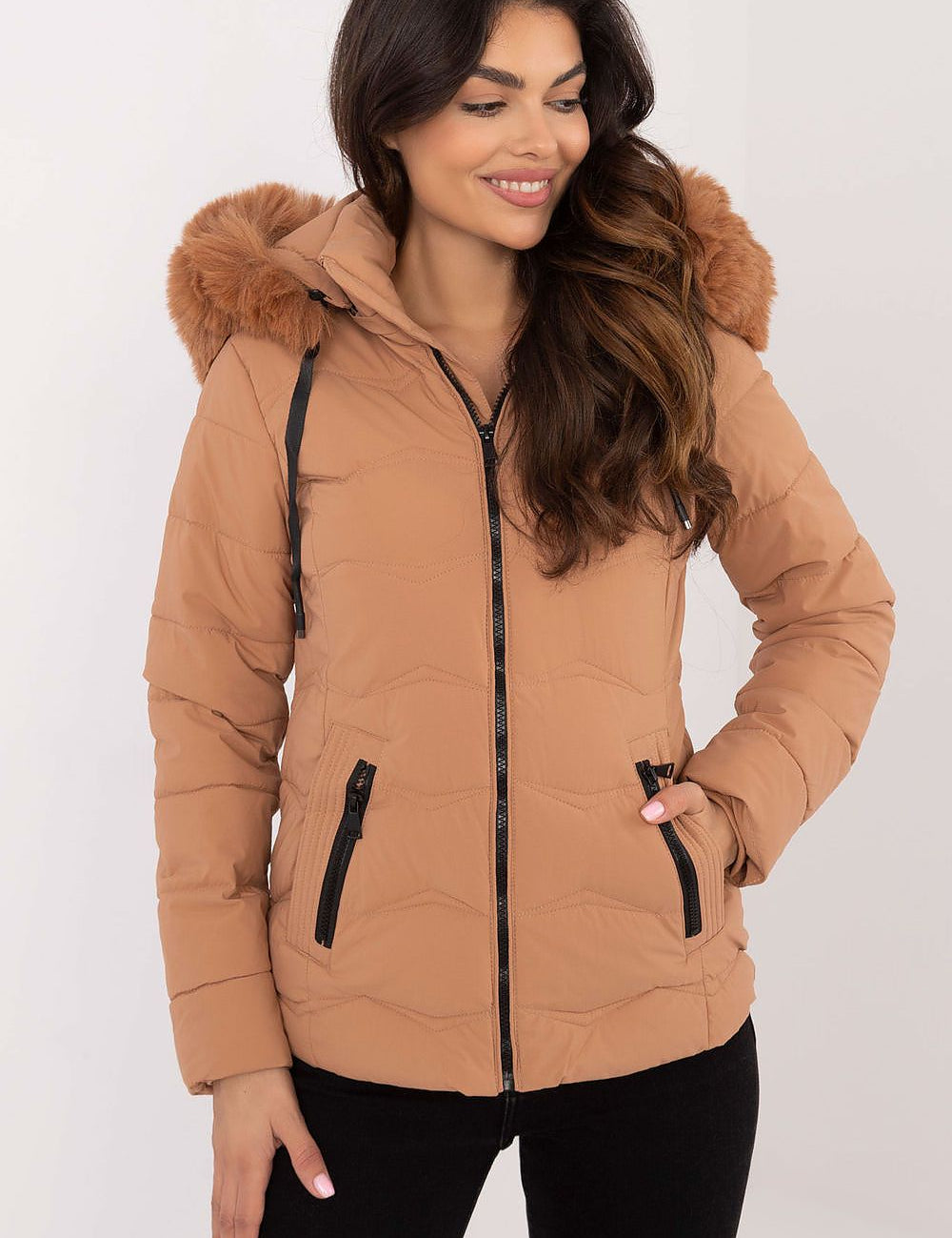 Woman wearing Veyra Short Quilted Jacket with detachable hood, showcasing stylish beige color and insulated design for cold weather.