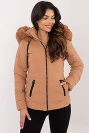 Woman wearing Veyra Short Quilted Jacket with detachable hood, showcasing stylish beige color and insulated design for cold weather.