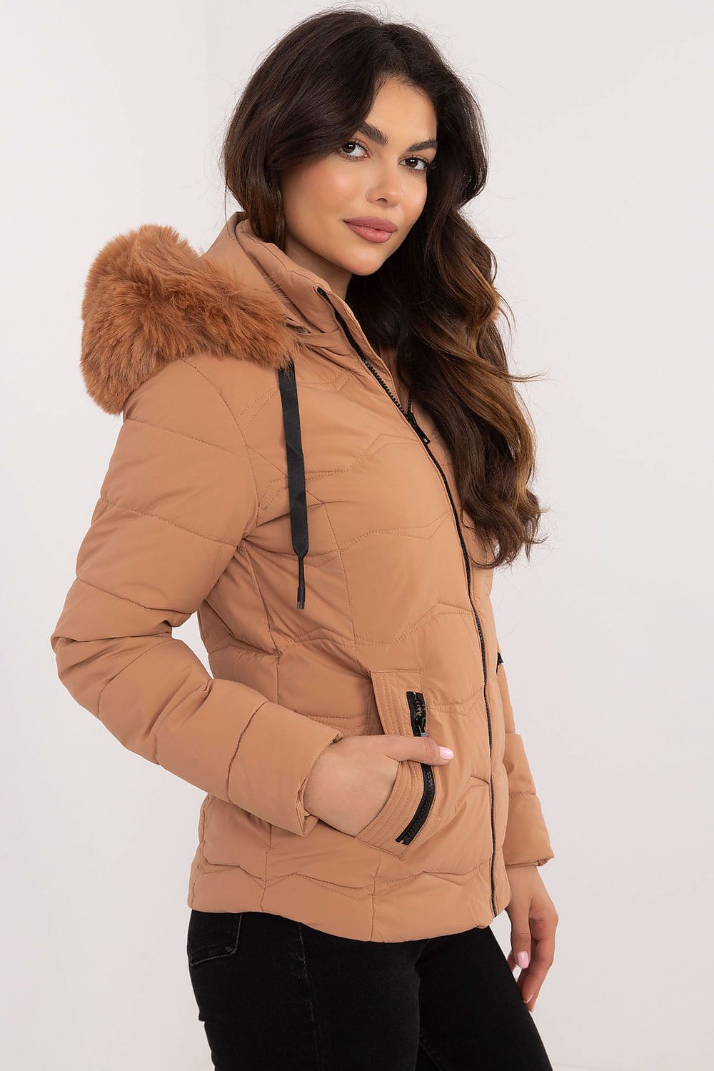 Woman wearing Veyra Short Quilted Jacket with detachable hood, showcasing sleek design and warm synthetic down filling.
