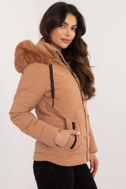 Woman wearing Veyra Short Quilted Jacket with detachable hood, showcasing sleek design and warm synthetic down filling.
