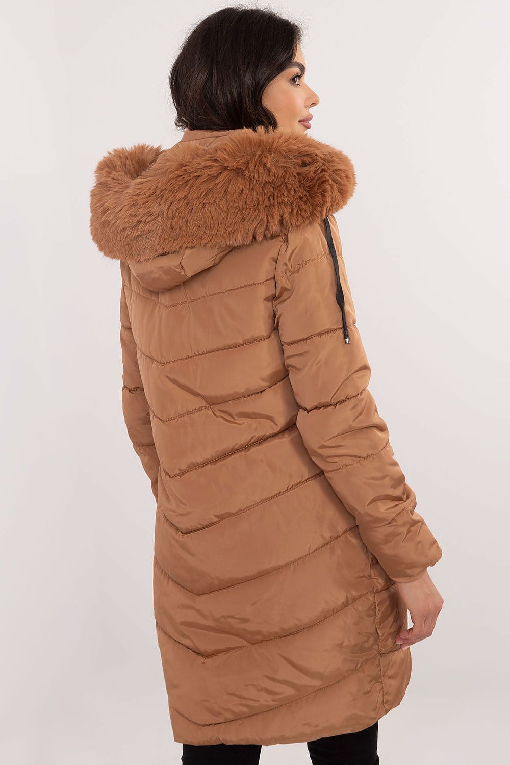 Woman wearing Aurlis Quilted Winter Jacket with detachable faux fur trim, showcasing back view.