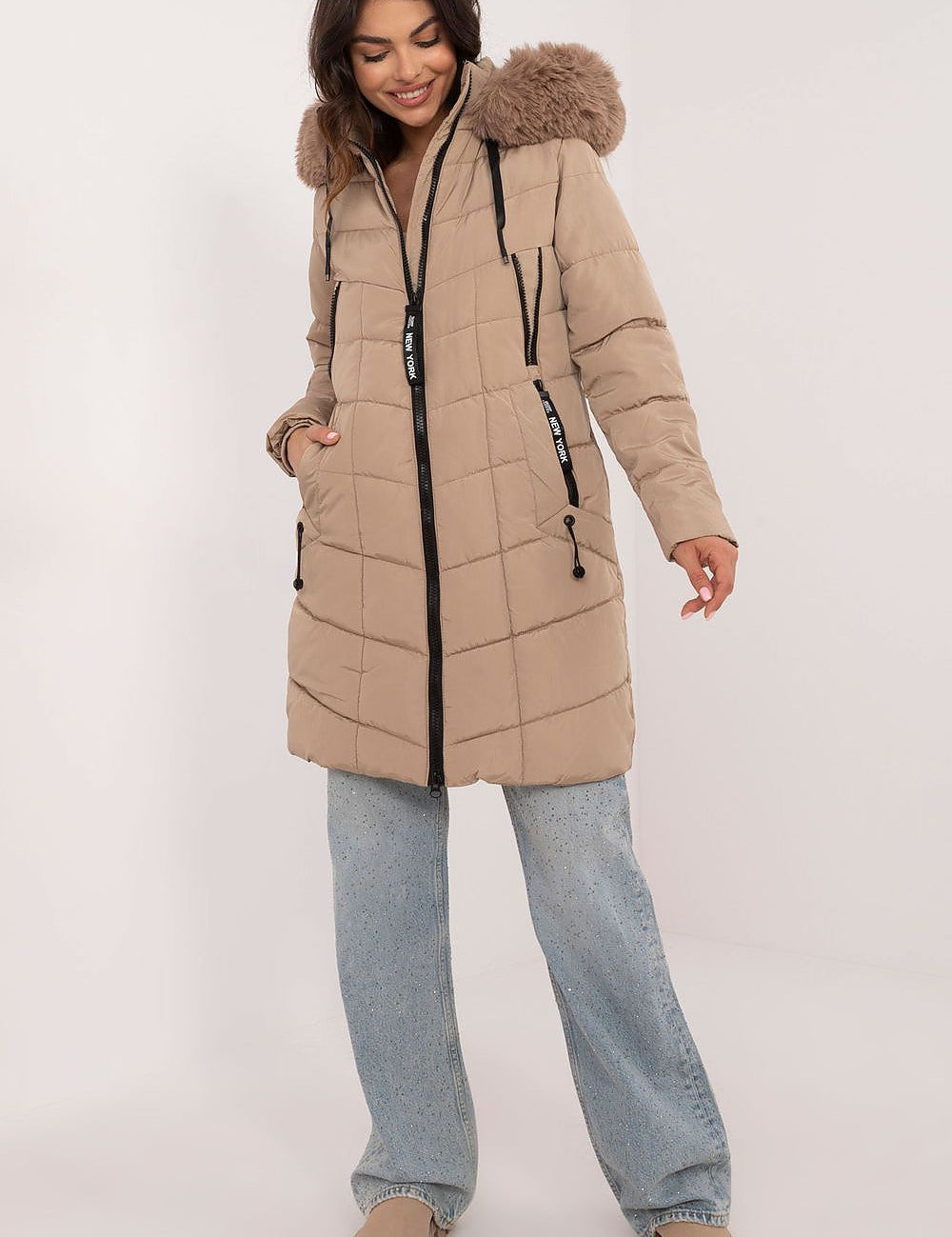 Woman wearing Aurlis Quilted Winter Jacket with faux fur trim, offering knee-length warmth and style.