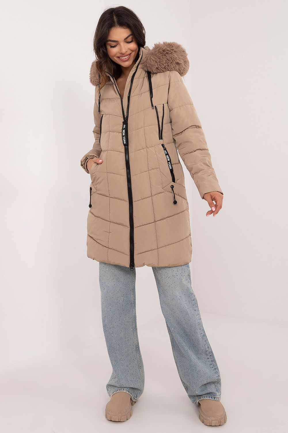 Woman wearing Aurlis Quilted Winter Jacket with faux fur trim, offering knee-length warmth and style.