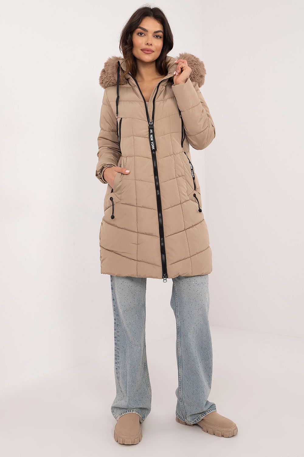 Woman wearing Aurlis Quilted Winter Jacket with detachable faux fur and knee-length design, showcasing warmth and style.