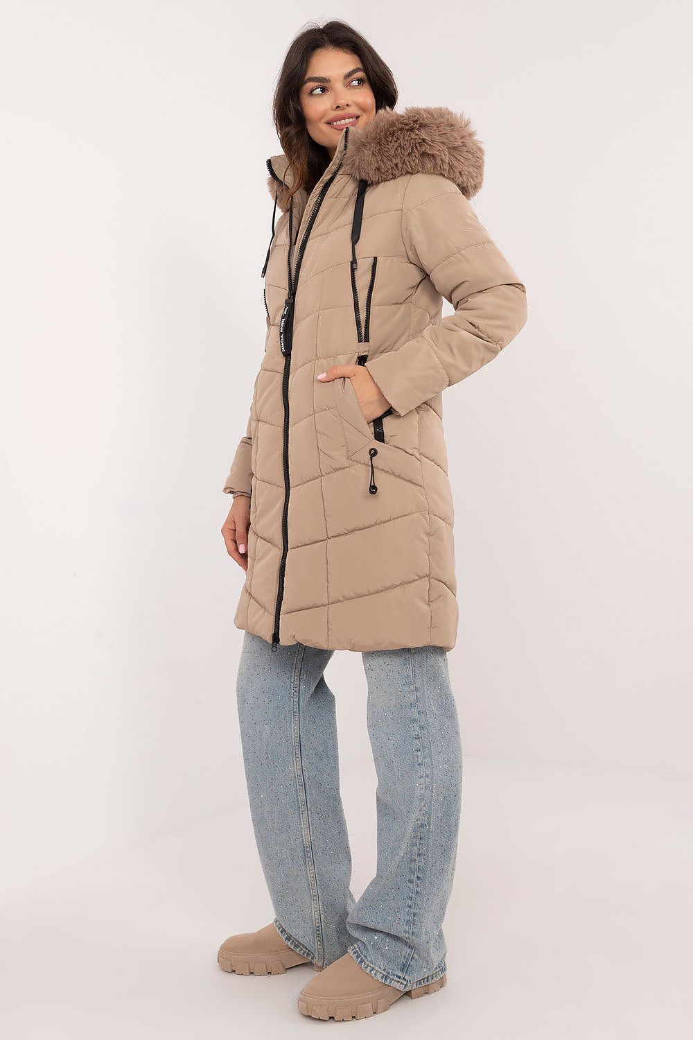 Aurlis Quilted Winter Jacket with faux fur hood, knee-length, beige, worn by model. Offers warmth and style for cold weather.