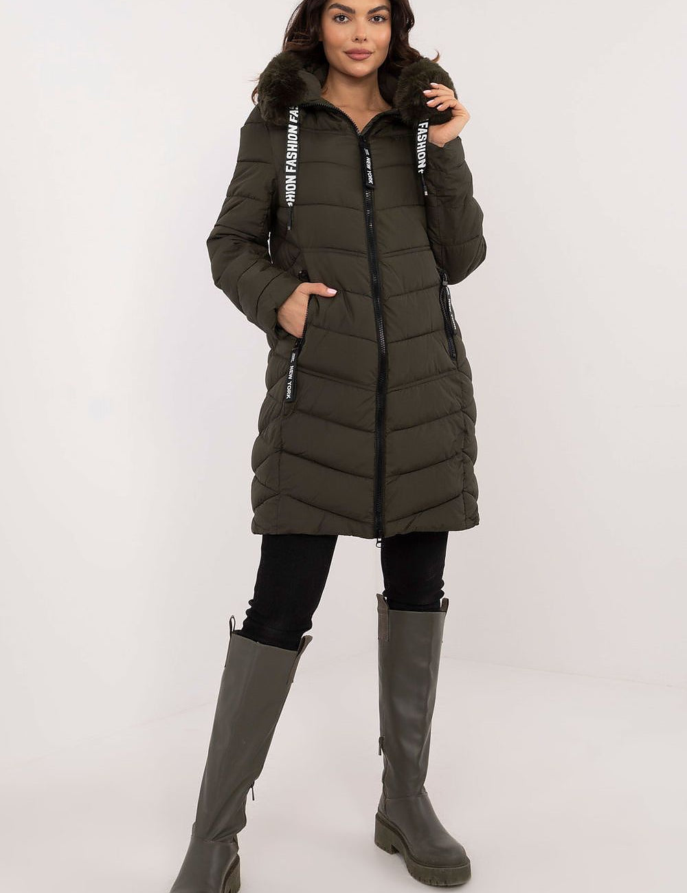 Woman wearing Frostveil Quilted Winter Jacket with detachable faux fur trim and knee-length coverage, ideal for cold weather.