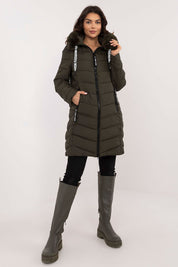 Woman wearing Frostveil Quilted Winter Jacket with detachable faux fur trim and knee-length coverage, ideal for cold weather.