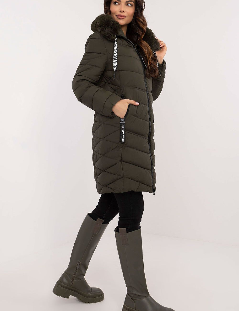 Woman wearing Frostveil Quilted Winter Jacket with detachable faux fur trim, showcasing warmth and style in knee-length design.