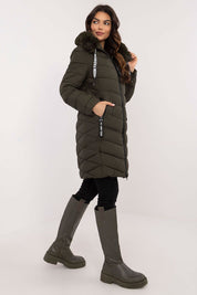 Woman wearing Frostveil Quilted Winter Jacket with detachable faux fur trim, showcasing warmth and style in knee-length design.