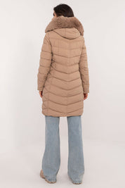 Back view of a woman wearing a beige Frostveil Quilted Winter Jacket with detachable faux fur trim, showcasing the quilted design.