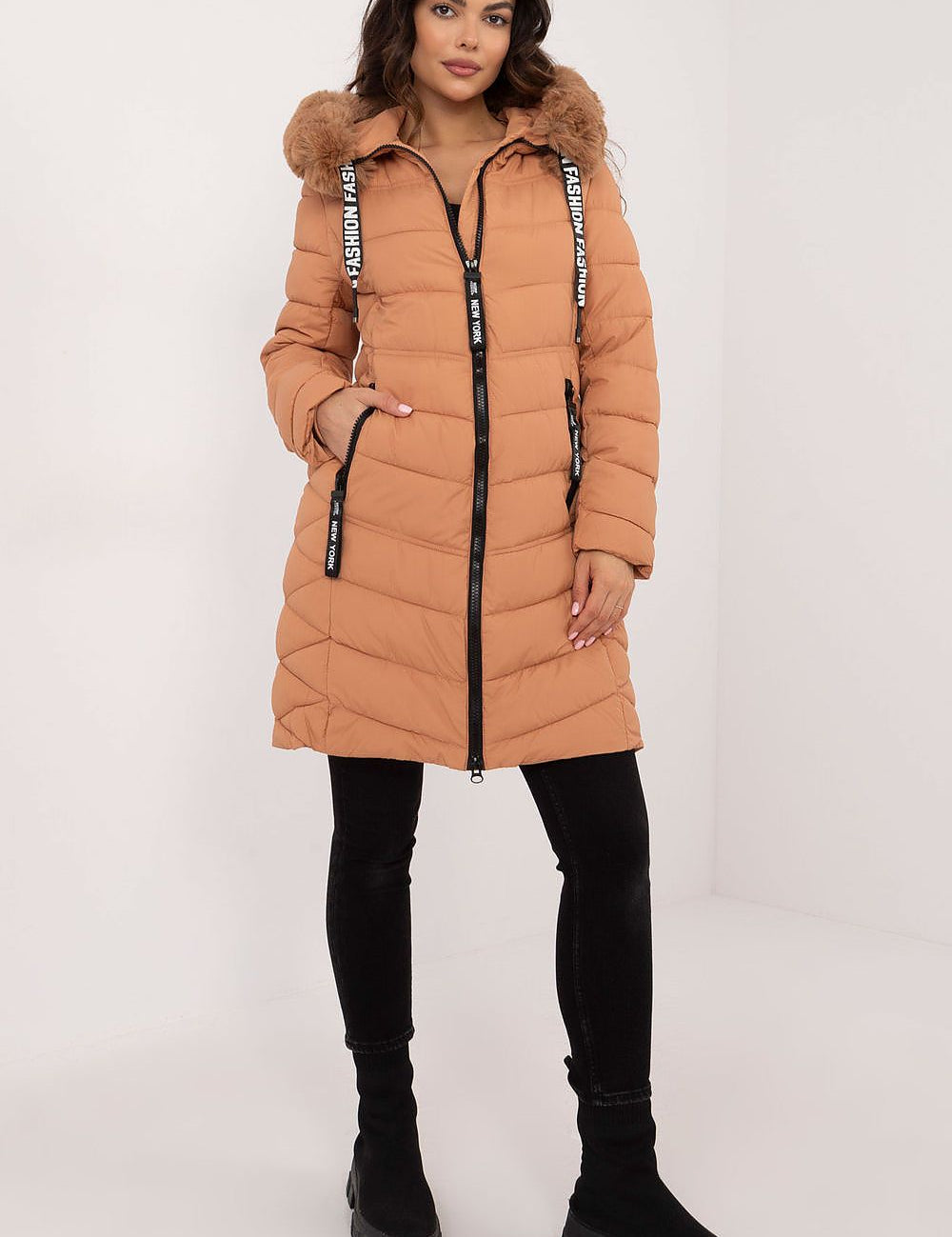 Woman wearing Frostveil Quilted Winter Jacket with faux fur trim, showcasing knee-length style and warmth for cold weather.