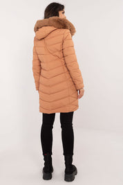 Woman wearing Frostveil Quilted Winter Jacket with detachable faux fur trim and knee-length design, back view.