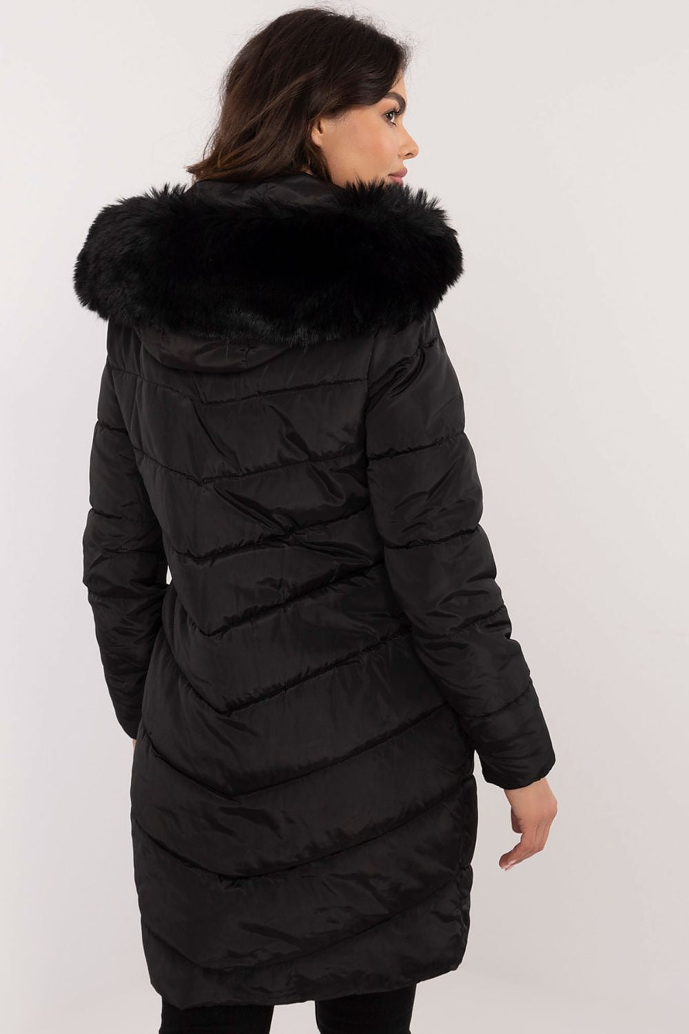 Woman wearing Aurlis Quilted Winter Jacket with faux fur trim, showing back view. Offers warmth and style for cold weather.