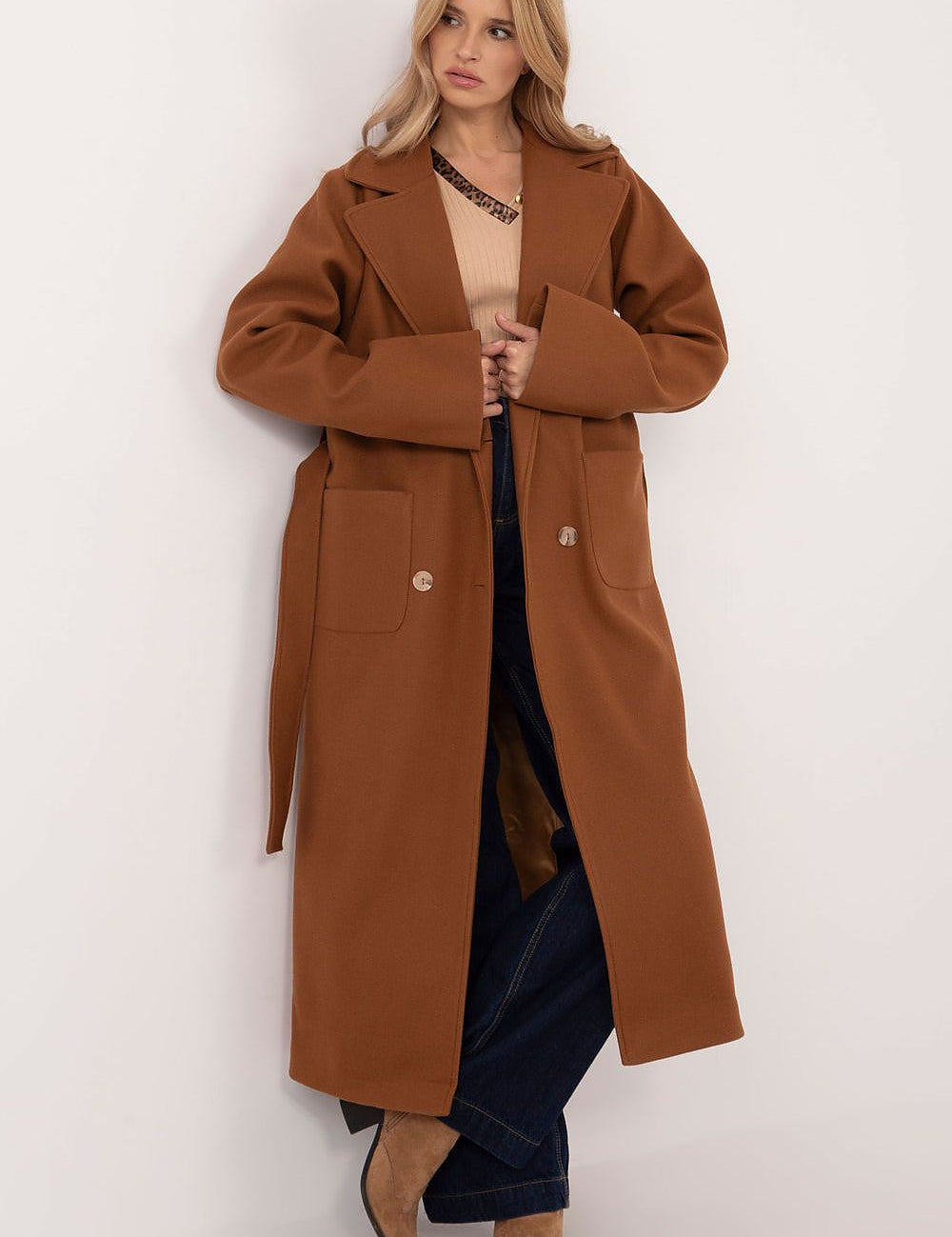 Woman wearing Olivanne Long Wool Blend Coat in brown, showcasing elegant design with wide lapels and waist tie, standing against white background.