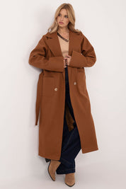 Woman wearing Olivanne Long Wool Blend Coat in brown, showcasing elegant design with wide lapels and waist tie, standing against white background.