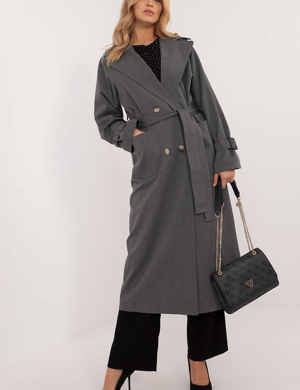 Woman wearing Elandra double-breasted trench coat, perfect for work and formal occasions, in a classic cotton blend with a calf-length cut.