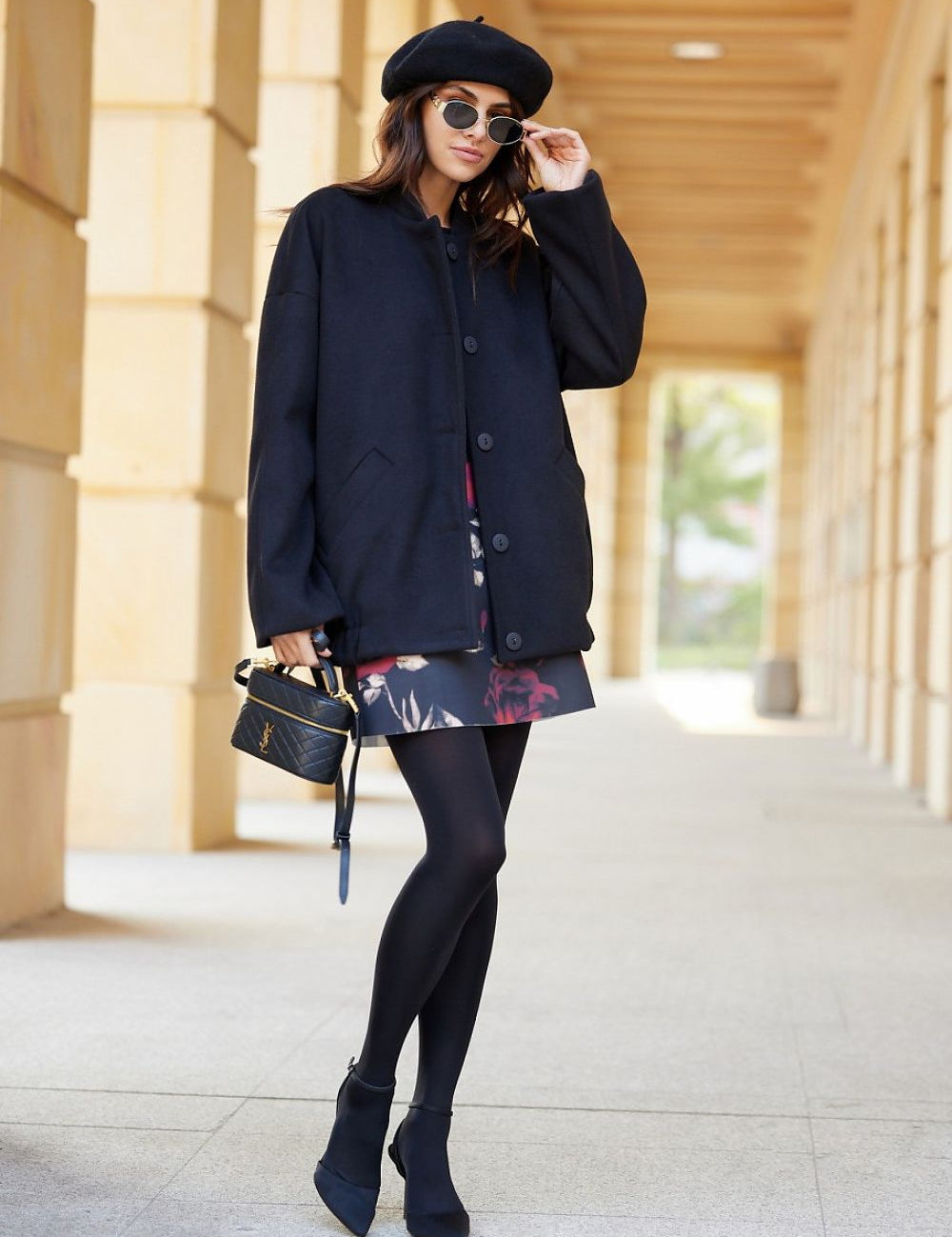 Woman in black Vernelle stand-collar buttoned jacket with beret and sunglasses, showcasing elegance and casual style in a relaxed fit.