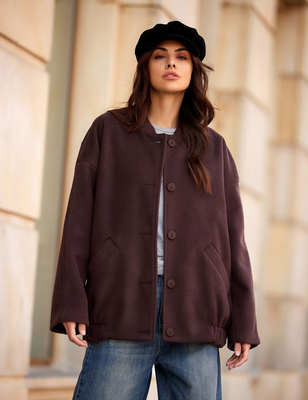 Woman wearing a Vernelle Stand-Collar Buttoned Jacket in dark fabric, paired with a stylish black beret, standing outdoors.
