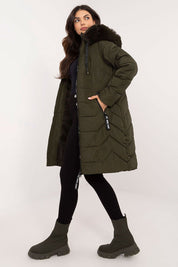 Woman modeling Elvarra Quilted Winter Down Coat with fur-trimmed hood, showcasing knee-length urban design in green, perfect for winter.