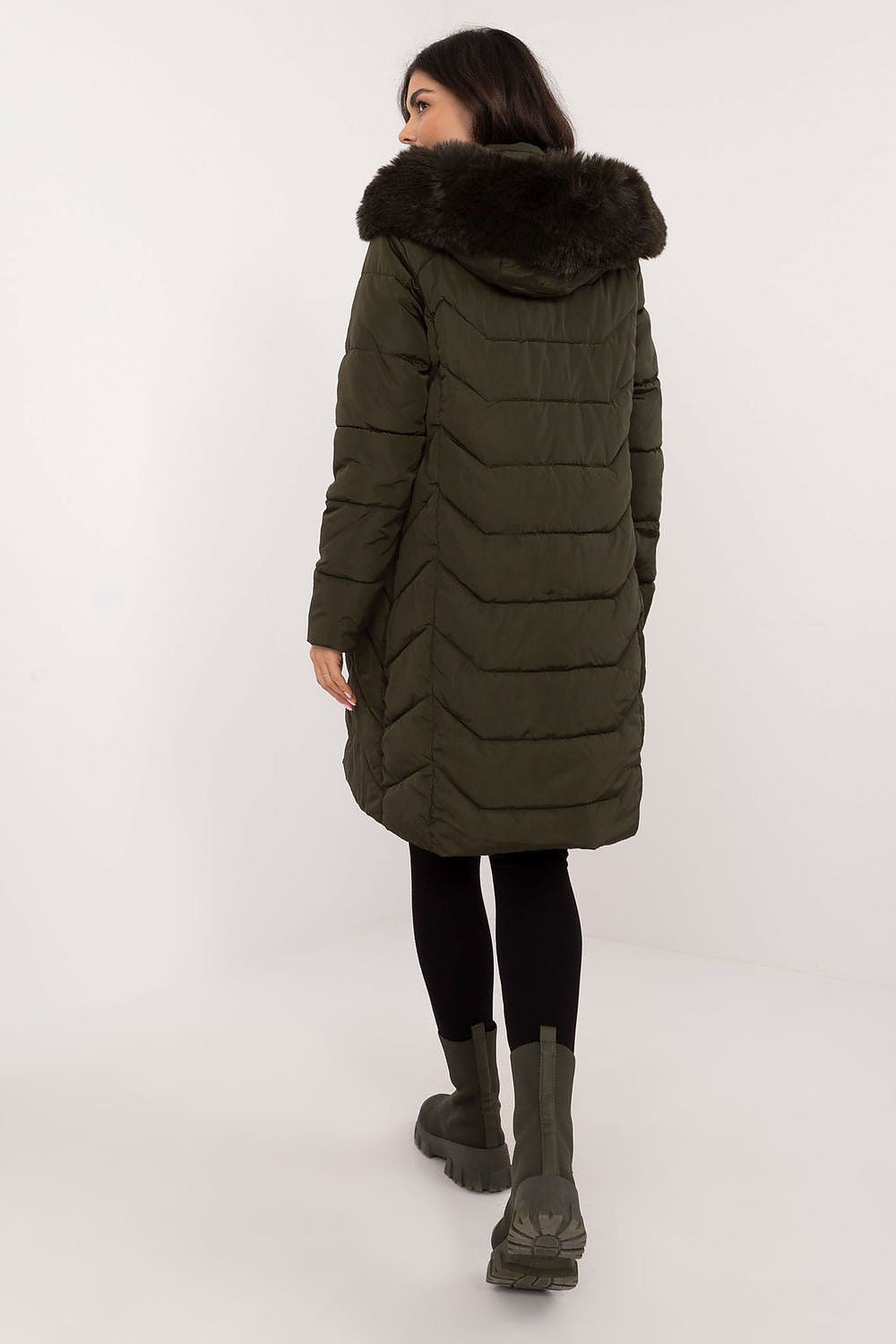 Back view of woman wearing Elvarra Quilted Winter Down Coat with hood and fur trim, showcasing knee-length design and urban style.