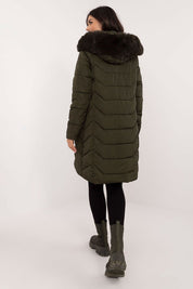 Back view of woman wearing Elvarra Quilted Winter Down Coat with hood and fur trim, showcasing knee-length design and urban style.
