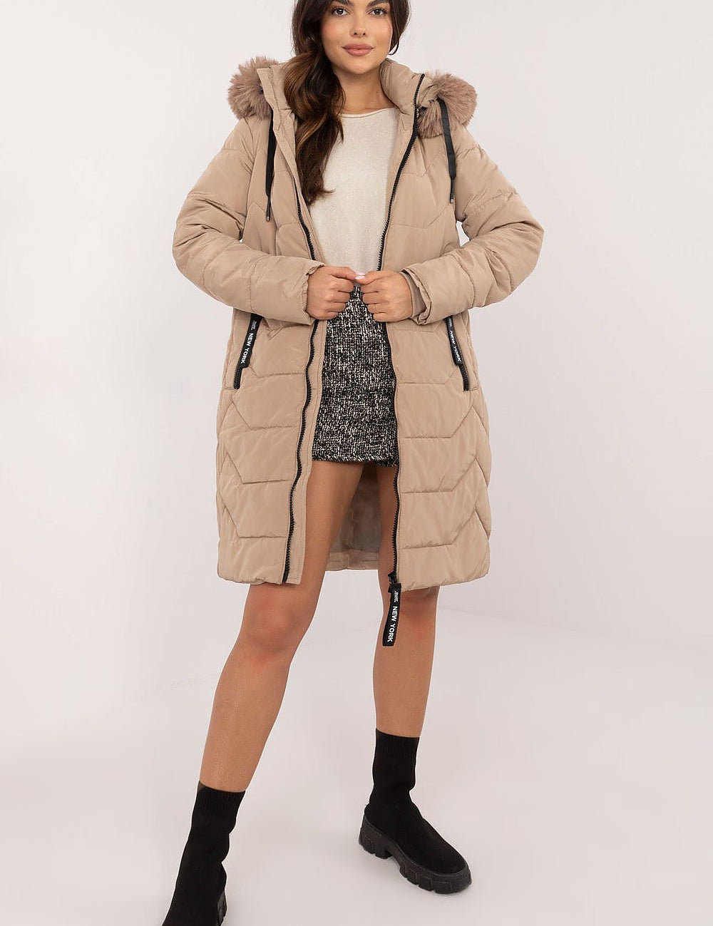 Woman wearing Elvarra Quilted Winter Down Coat with detachable fur hood, showcasing elegant and warm autumn-winter fashion.