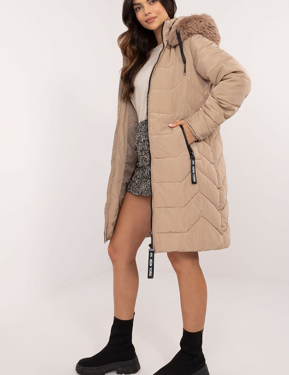 Woman wearing Elvarra quilted winter down coat with detachable hood, showcasing casual urban style for autumn and winter seasons.