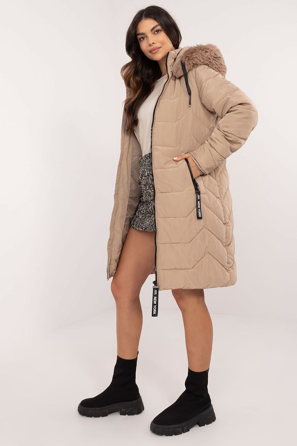 Woman wearing Elvarra quilted winter down coat with detachable hood, showcasing casual urban style for autumn and winter seasons.