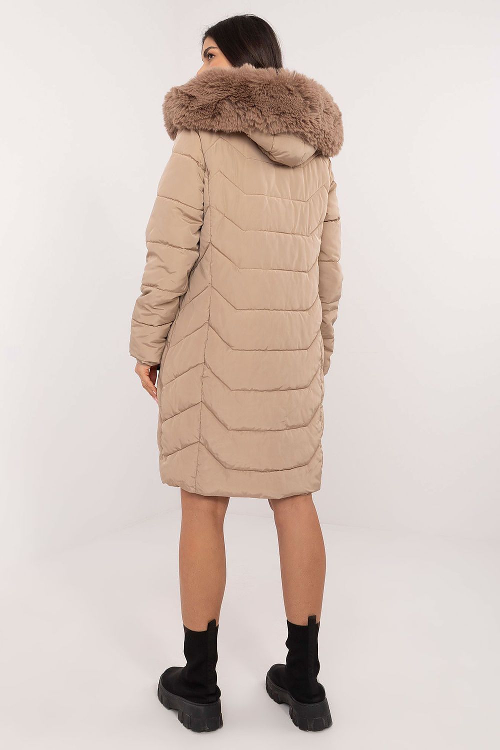 Woman wearing Elvarra Quilted Winter Down Coat with fur-trimmed hood, knee-length, ideal for autumn and winter urban fashion.