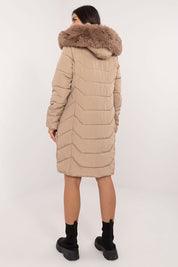 Woman wearing Elvarra Quilted Winter Down Coat with fur-trimmed hood, knee-length, ideal for autumn and winter urban fashion.