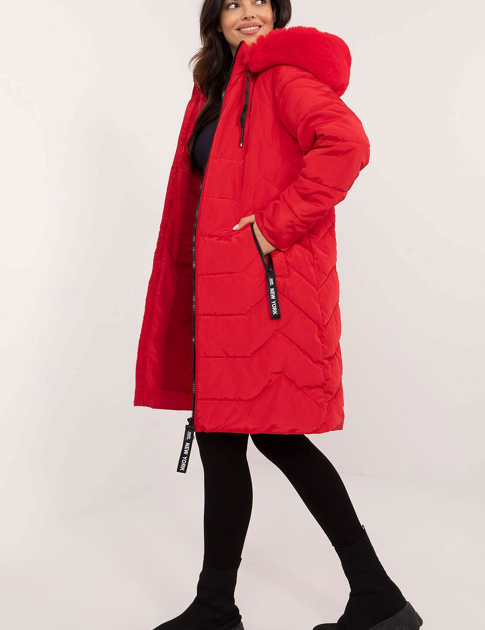 Woman wearing a red Elvarra quilted winter down coat with detachable hood, showcasing modern autumn and winter fashion style.